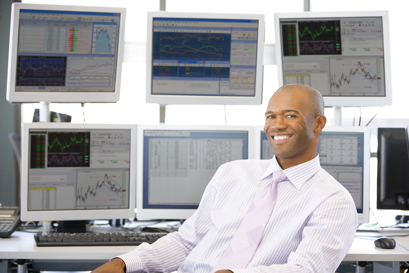 Portrait Of Stock Trader In Front Of Computer Monitors